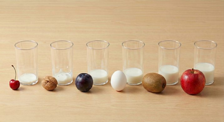 Visual comparison of baby stomach sizes using fruits and milk cups